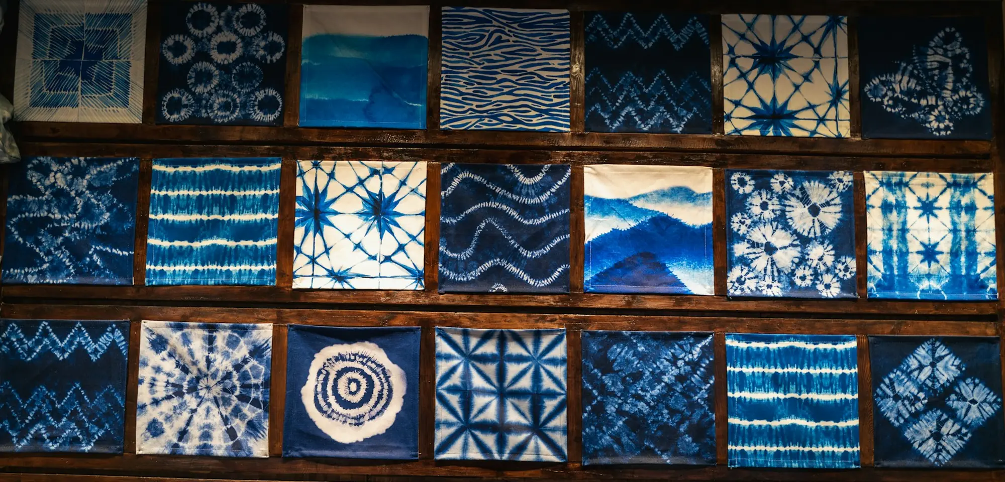 Un mur de carrés de tissu teints à l'indigo, motifs noués à la main